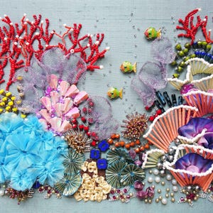 May include: A colorful, handcrafted coral reef scene with red coral, blue flowers, and various other sea elements. The artwork includes small, yellow and green fish, and is embellished with beads and sequins.
