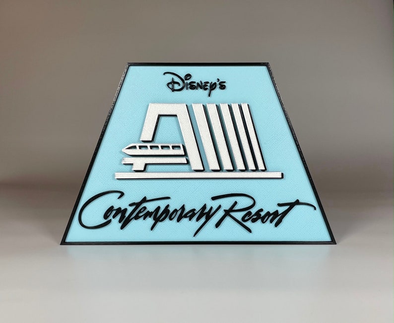 May include: A blue and white sign with black trim that reads "Disney's Contemporary Resort". The sign features a stylised image of the resort's monorail system.