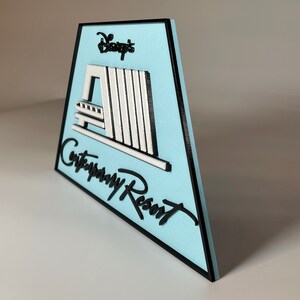May include: A blue and black sign with the text "Disney's Contemporary Resort" and a white silhouette of the resort's monorail system.