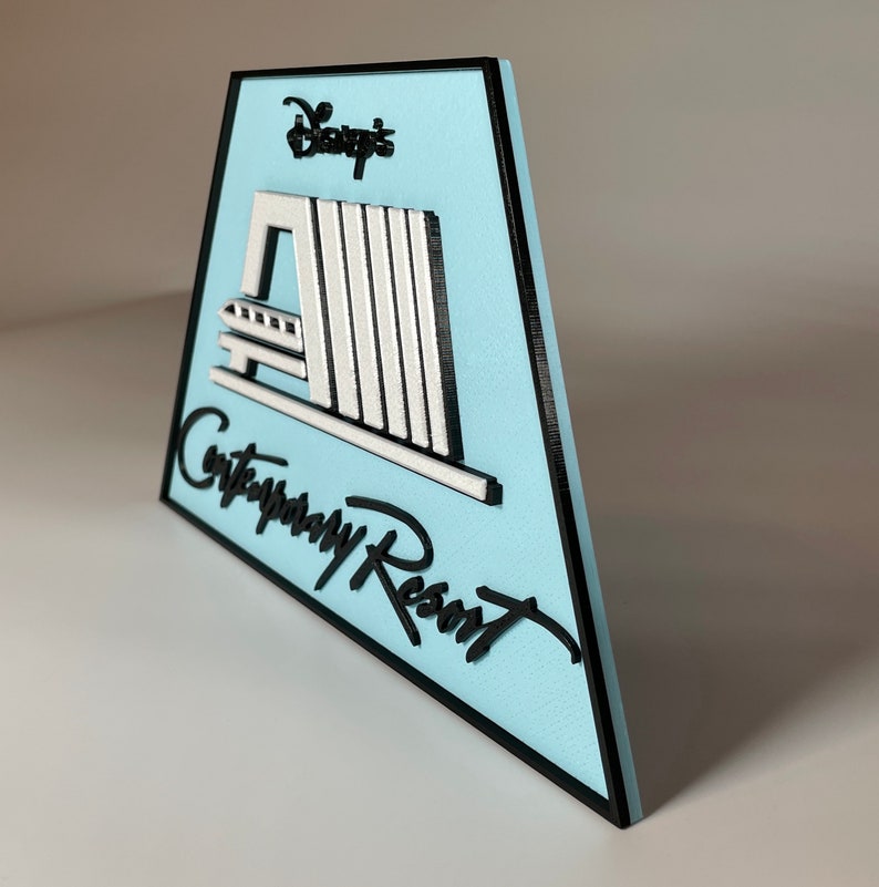 May include: A blue and black sign with the text "Disney's Contemporary Resort" and a white silhouette of the resort's monorail system.