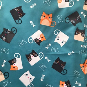 May include: A teal blue fabric with a repeating pattern of black, white, orange, and brown cats. The cats are in various poses and have different facial expressions. The fabric has the word "CATS" printed in white throughout the pattern.
