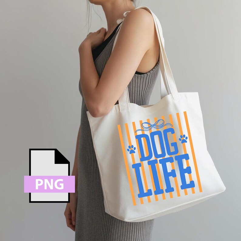 May include: Cream-colored tote bag with orange vertical stripes and the words "DOG LIFE" in blue. The design includes paw prints and a bow. The bag has long handles and is made of a sturdy fabric.