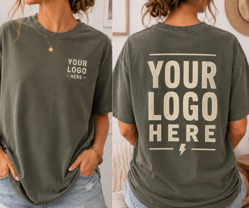 May include: A dark gray short-sleeve t-shirt featuring the text YOUR LOGO HERE printed in a light beige color. The front displays the text on the left chest, while the back features the same text in a larger size with a lightning bolt icon.