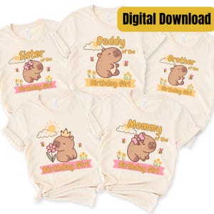 Op de afbeelding: Vijf crèmekleurige t-shirts met capybaragraphics en de woorden "Sister", "Daddy", "Brother" en "Mommy" boven de tekst "Birthday Girl". De shirts hebben een digitaal downloadlabel.