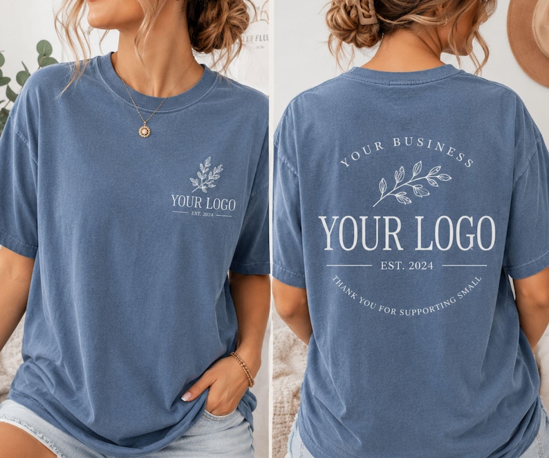 May include: A blue short-sleeve t-shirt featuring a white graphic on the front left chest with a leaf sprig and the text YOUR LOGO EST. 2024. The back displays a larger version of the same design with the text YOUR BUSINESS and THANK YOU FOR SUPPORTING SMALL.