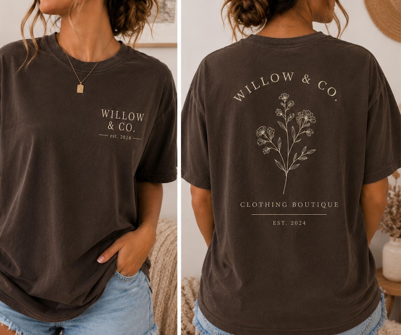May include: A dark charcoal gray short-sleeve t-shirt featuring the text WILLOW & CO. est. 2024 on the front chest. The back displays a botanical line drawing of wildflowers with the text WILLOW & CO. CLOTHING BOUTIQUE and est. 2024 below.
