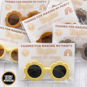 Peut inclure: Plusieurs paires de lunettes de soleil jaunes, marron et grises sont présentées. Chaque paire est emballée avec une carte indiquant "Merci d'avoir rendu ma fête plus lumineuse ! Premier anniversaire de Hayden".