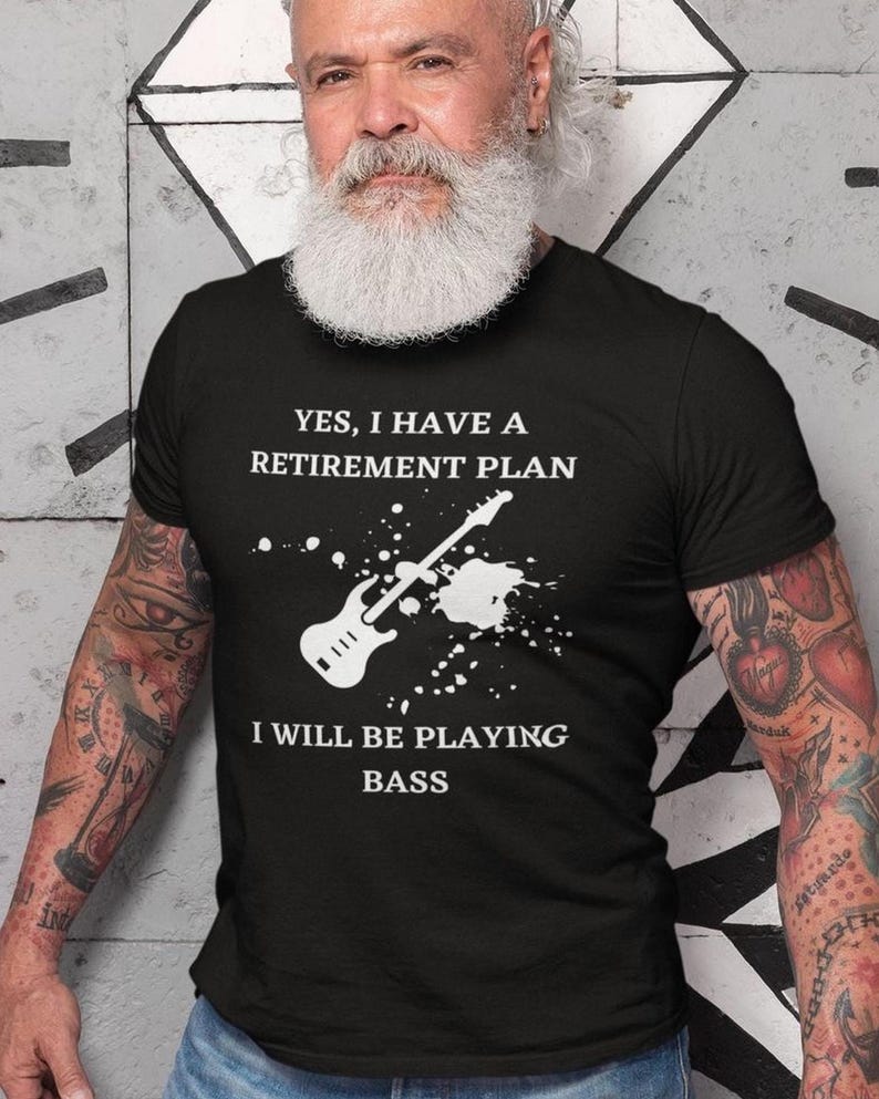 A man with a long white beard wearing a black t-shirt with a humorous text and graphic design.