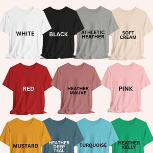a collection of unisex t-shirt colors, including white, black, athletic heather, soft cream, red, pink, mustard, Heather Deep Teal, and Heather Kelly.