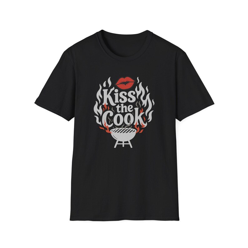 A black t-shirt with a graphic design featuring a pair of lips and flames, along with the text "Kiss the Cook" in a stylized font.
