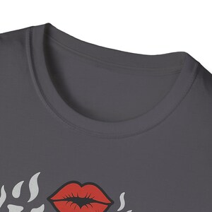a close-up view of a gray t-shirt with a graphic design featuring a pair of red lips and flames.