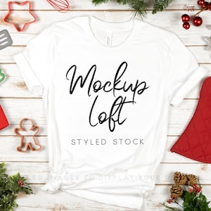May include: White t-shirt mockup with the text "Mockup Loft" and "Styled Stock" on a white wood background with Christmas decorations.