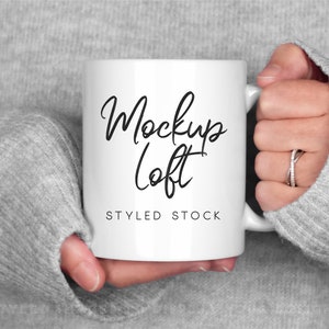 May include: White ceramic mug with a black handwritten inscription that says "Mockup Loft" and the text "Styled Stock" below it.