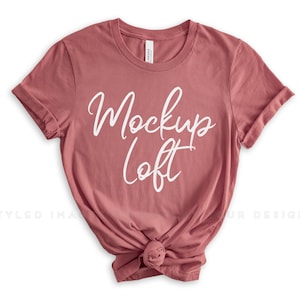 May include: A mauve colored t-shirt with a white text design that says "Mockup Loft".