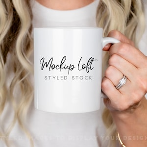 May include: White ceramic mug with a black cursive inscription that reads "Mockup Loft Styled Stock".