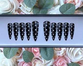 May include: Set of ten black stiletto false nails with white polka dots.