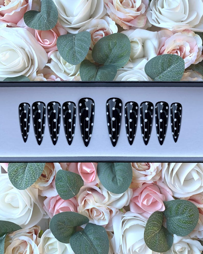 May include: Set of ten black stiletto false nails with white polka dots.