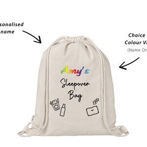 May include: A white drawstring bag with the text "Amy's Sleepover Bag" in rainbow colors. The bag has a black and white illustration of a popcorn bucket, a soda can, and a sleeping envelope.