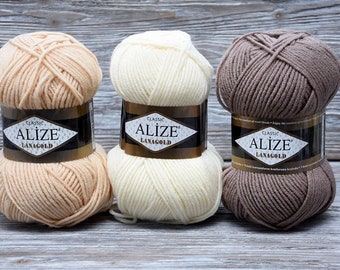 May include: Three skeins of yarn in beige, white, and brown. The yarn is labeled "Alize Classic Lanagold".