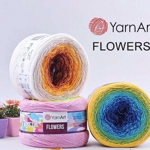 May include: Three colorful YarnArt Flowers yarn skeins. One is white, orange, and brown; another is pink; and the third is yellow, blue, and green. The YarnArt logo and the word "FLOWERS" are visible.