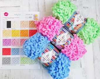 May include: Five skeins of Alize Puffy Fine yarn in different colors: light green, pink, light blue, blue, and a color chart with various yarn colors. The yarn is a fluffy, textured yarn that is perfect for crocheting or knitting.