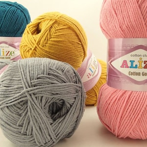May include: Four balls of yarn in different colors: teal, yellow, gray, and pink. Each ball has a label that says "cotton club alize Cotton Gold".