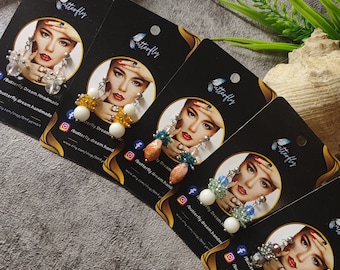 May include: Five cards with images of women wearing earrings. The earrings are made with beads and crystals in various colors, including white, blue, green, orange, and silver. The cards have the text "Butterfly Dream. Handmade" and a website address.