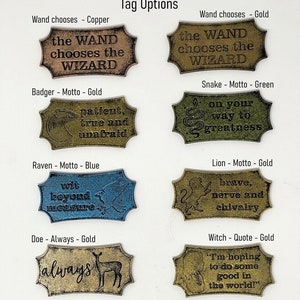 May include: Nine different metal tags with various designs and sayings. The tags are in different colours, including gold, copper, green, and blue. The tags feature sayings like "the wand chooses the wizard", "patient, true and unafraid", "wit beyond measure", "always", "on your way to greatness", "brave, nerve and chivalry", and "I'm hoping to do some good in the world!"