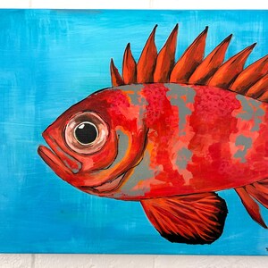 May include: A painting of a bright red fish with a large eye and spiky dorsal fins, set against a solid light blue background. The fish features mottled gray patches across its body and dark red fins, rendered in a bold, expressive style.