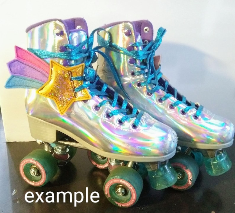May include: A pair of iridescent roller skates with teal laces and a rainbow star and wing applique. The wheels are green and pink.