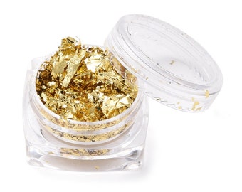 May include: A clear plastic jar filled with gold leaf flakes. The jar has a lid that is also clear plastic.