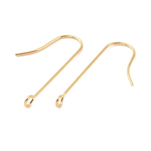 Puede incluir: Un par de ganchos para pendientes de color dorado. Los ganchos son de metal y tienen un diseño simple y elegante.