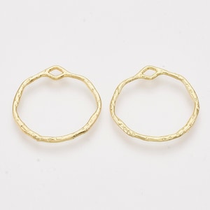 May include: Two gold-colored metal hoops with a textured surface. The hoops have a small opening at the top.