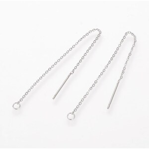 May include: A pair of silver threader earrings. Each earring has a fine chain with a straight bar at one end and a small ring at the other. The earrings are shown against a white backdrop.