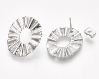 May include: A pair of silver earrings with a scalloped design. The earrings are round and have a hole in the center. The earrings are attached to a post.
