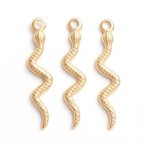 May include: Three gold snake charms with a textured surface. The charms are approximately 5 cm long and have a loop at the top for attaching to jewellery.