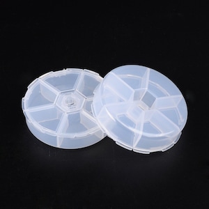 以下が含まれることがあります： 透明なプラスチック製の丸いピルボックスが2つ。それぞれ6つのコンパートメントがあります。ボックスは互いに積み重ねられています。
