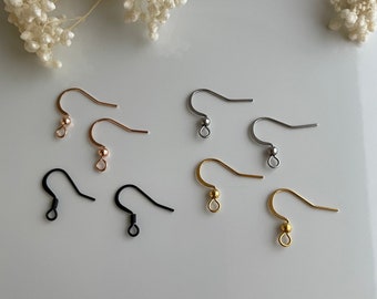 May include: Six pairs of earring hooks in different colors: black, silver, gold, and rose gold. The hooks are made of metal and have a small loop at the top.