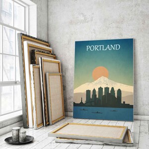 May include: A vintage-style poster with the word "PORTLAND" in white text at the top. The poster features a silhouette of the Portland skyline with Mount Hood in the background. The sun is setting behind the mountain, casting an orange glow over the city.
