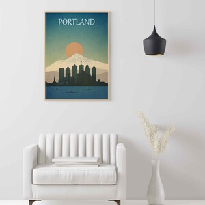 May include: A minimalist poster with a blue, green and orange colour scheme depicting the Portland skyline with Mount Hood in the background. The text "PORTLAND" is at the top of the poster.