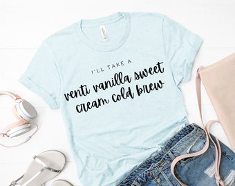 May include: A light blue t-shirt with the text "I'll take a venti vanilla sweet cream cold brew" printed in black.