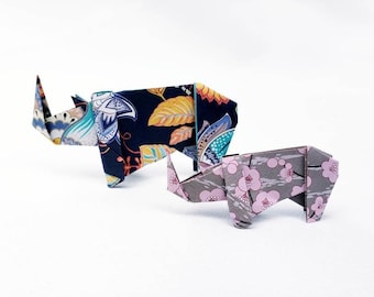 Puede incluir: Dos rinocerontes de origami, uno con un patrón floral azul, verde y amarillo y el otro con un patrón floral gris y rosa.