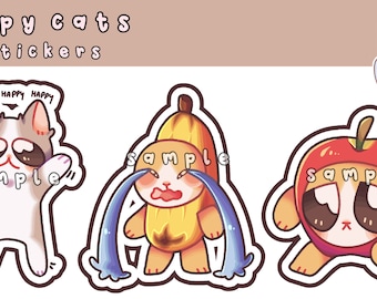 May include: Three 3-inch stickers featuring cartoon cats wearing different costumes. The first cat is wearing a white and gray cat costume with the words "Happy Happy Happy" above its head. The second cat is wearing a yellow banana costume and is crying blue tears. The third cat is wearing a red apple costume. All three cats have big eyes and are smiling.