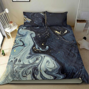 Peut inclure: Une parure de lit bleue et blanche avec un motif marbré et des accents dorés. La parure de lit comprend une housse de couette et deux taies d'oreiller.