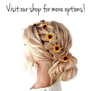 May include: A woman with blonde hair wearing a braid with five small sunflower hair clips. The sunflower hair clips are yellow with brown centers.