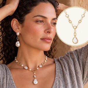 May include: A gold-toned necklace and matching drop earrings set featuring white baroque pearls and rectangular metal links. The necklace has a central drop pendant, and the earrings mirror the design with a single pearl and link.
