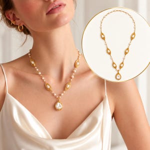 May include: A gold-toned necklace featuring a series of small white pearls interspersed with textured, elongated gold-toned oval links. The necklace culminates in a larger, teardrop-shaped white pearl pendant encased in a gold-toned frame.