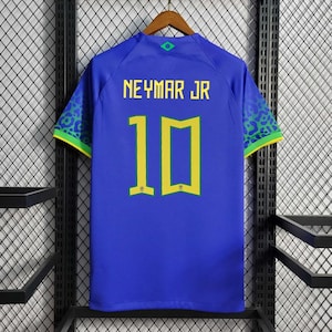 Może przedstawiać: Niebieska koszulka piłkarska z ż&oacute;łtymi i zielonymi akcentami. Na plecach koszulki nadrukowano nazwisko "NEYMAR JR" i numer "10" w kolorze ż&oacute;łtym.