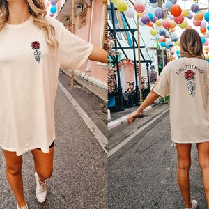 Peut inclure: Un t-shirt surdimensionn&eacute; de couleur cr&egrave;me avec un motif repr&eacute;sentant une rose et une main squelettique. Le texte "Run Little Mouse" est imprim&eacute; au dos du t-shirt.