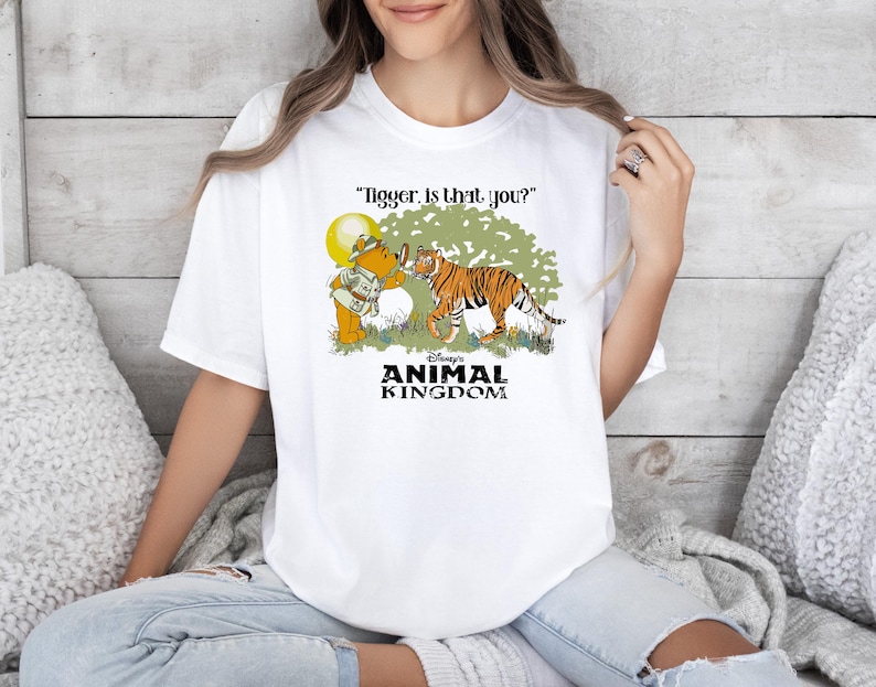 May include: White t-shirt with a cartoon image of Winnie the Pooh and Tigger. The text "Tigger, is that you?" and "Disney's Animal Kingdom" are printed on the shirt.